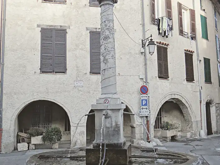 Place de la Fontaine, fontaine et arcades, au Broc